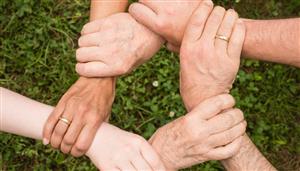 Five adult hands holding wrists: show of collaboration 
