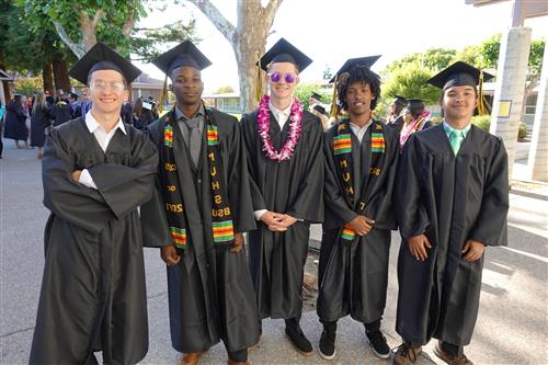 Five diverse MVHS male grads smiling in cap and gown 